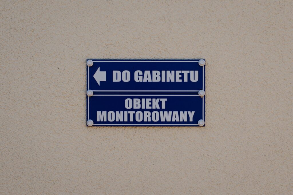 Tabliczka kierująca do gabinetu na ścianie budynku.